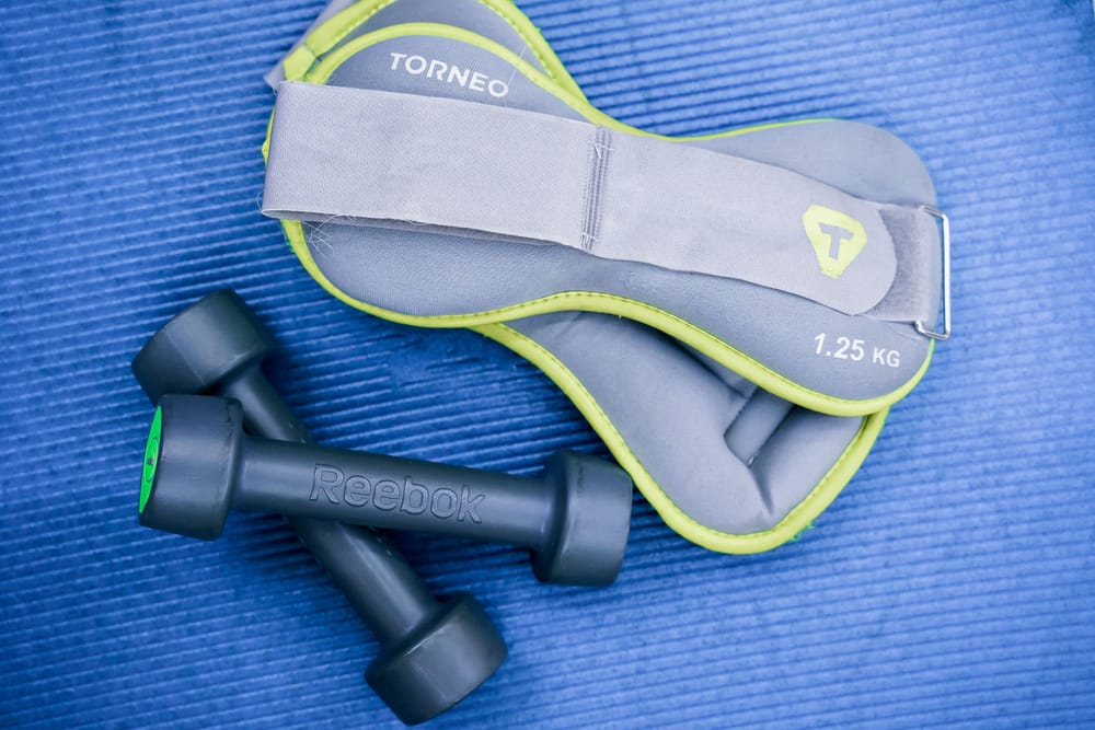 Small dumbbells and soft weights arranged on an exercise mat